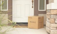 brown cardboard box beside white wooden door