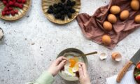 person holding stainless steel spoon with sliced orange fruit