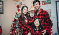 a family poses for a picture in front of a christmas tree