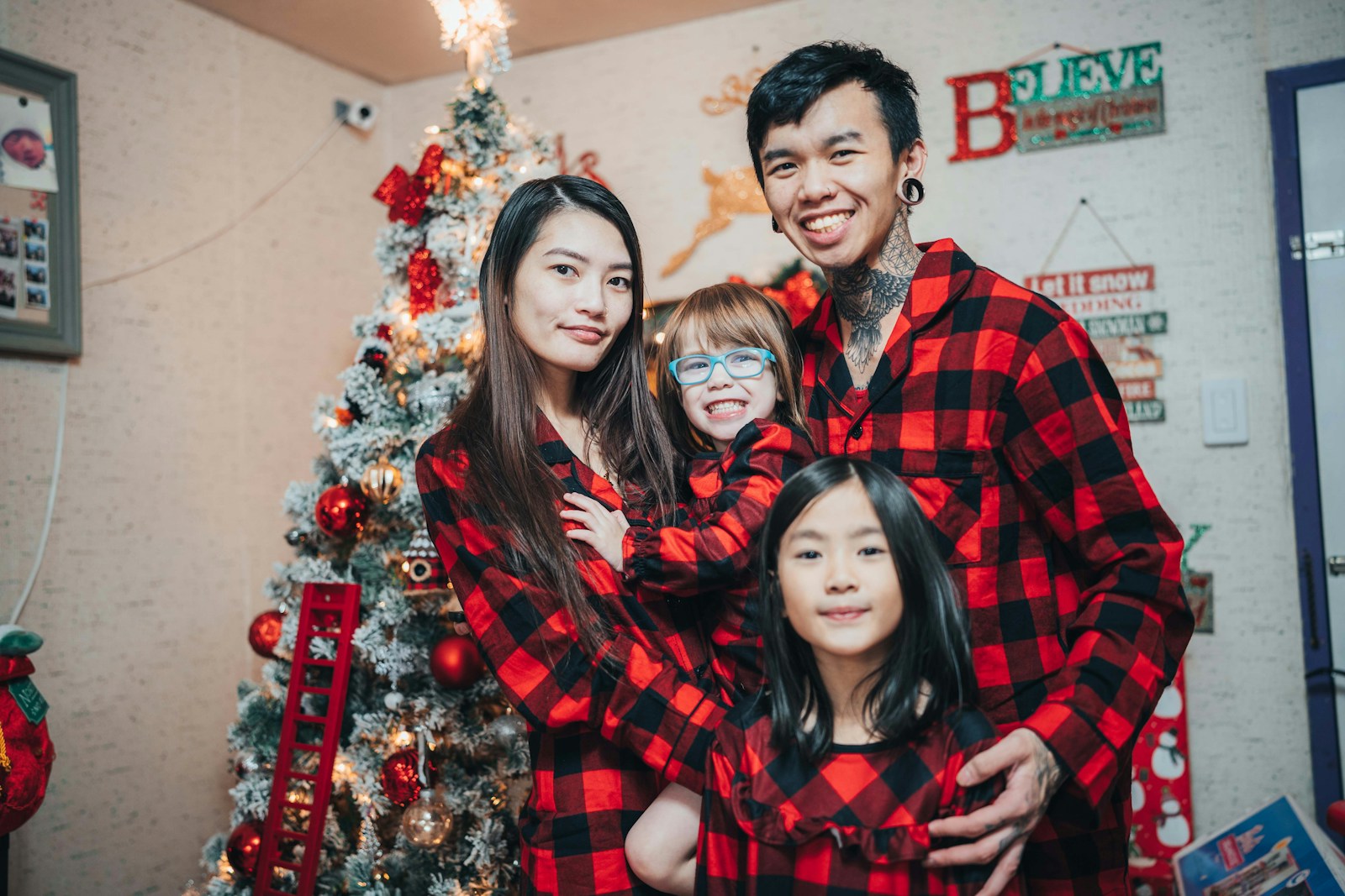 a family poses for a picture in front of a christmas tree
