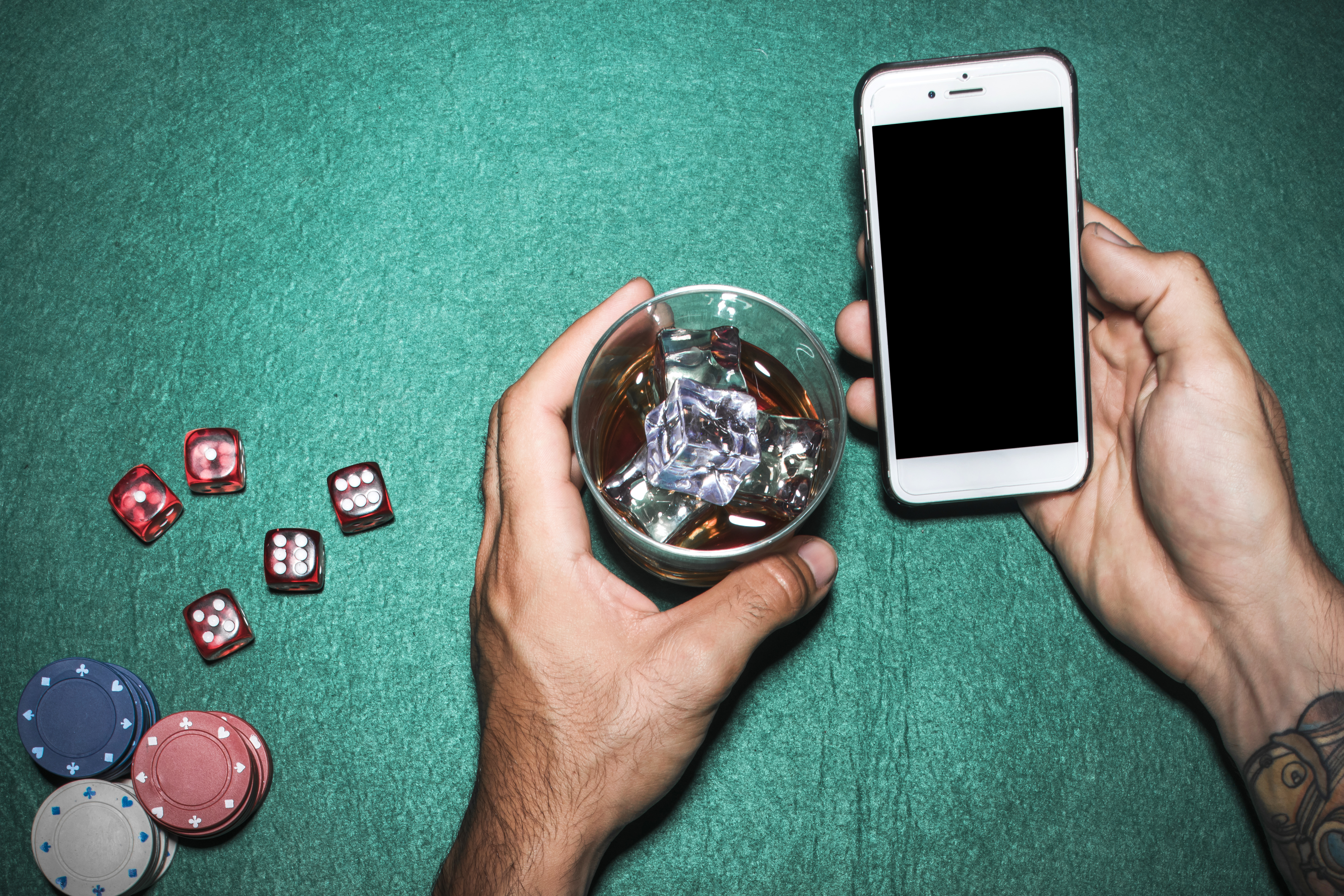 overhead view man s hand holding cellphone whisky glass poker table