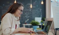 Woman working on a laptop in a modern office.